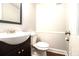 Powder room features a dark vanity and white toilet, perfect for guests at 4262 Hambrick Way, Stone Mountain, GA 30083