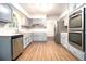 Modern kitchen with stainless steel appliances, quartz countertops, and wood-look flooring at 4262 Hambrick Way, Stone Mountain, GA 30083