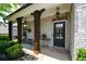 Cozy front porch with rustic columns, inviting seating, and decorative hanging plants at 4265 Pleasant Woods Dr, Cumming, GA 30028