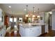 Eat-in kitchen with island bar stools open to Gathering room and fireplace at 4265 Pleasant Woods Dr, Cumming, GA 30028