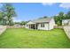 Spacious backyard with lush green grass, a wooden fence, and a covered patio at 122 Riverbirch Way, Dallas, GA 30157