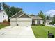 Inviting one-story home with a well-kept lawn, a two-car garage, and a welcoming entrance, showcasing suburban charm at 122 Riverbirch Way, Dallas, GA 30157