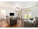 Bright living room with hardwood floors, ceiling fan, and doors to the backyard at 122 Riverbirch Way, Dallas, GA 30157