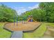 A colorful playground sits nestled within a lush green park-like setting at 122 Riverbirch Way, Dallas, GA 30157