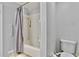 Bathroom with a white tiled shower and tub, grey shower curtain, and low-flow toilet at 830 Bonnie Glen Se Dr, Marietta, GA 30067