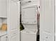 A stacked white washer and dryer are located in a closet behind bifold doors at 830 Bonnie Glen Se Dr, Marietta, GA 30067