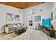 Cozy living room features a wooden ceiling, plush grey sofa, modern TV, and an open entryway at 830 Bonnie Glen Se Dr, Marietta, GA 30067