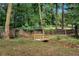 Backyard featuring a small bridge over a rock-lined creek, surrounded by trees at 230 Sheringham Dr, Roswell, GA 30076