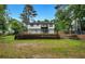 Backyard view of a home featuring a balcony, steps, and a retaining wall at 230 Sheringham Dr, Roswell, GA 30076