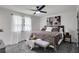Cozy bedroom with large window, neutral decor, ceiling fan, and comfortable bedding at 230 Sheringham Dr, Roswell, GA 30076