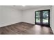 Bright room with dark wood floors and glass patio doors leading to the backyard at 230 Sheringham Dr, Roswell, GA 30076