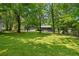 Spacious backyard featuring mature trees and lush green grass offering a serene outdoor space for relaxation and recreation at 2661 Fleur De Lis Pl, Atlanta, GA 30360