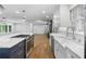 View of the kitchen island, white cabinets, and stainless steel appliances in an open layout at 2661 Fleur De Lis Pl, Atlanta, GA 30360