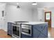 Kitchen island featuring a cooktop and oven, light countertop and dark cabinetry at 2661 Fleur De Lis Pl, Atlanta, GA 30360