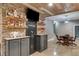 Basement features a custom wet bar, TV, and gaming area with stone accents at 7269 Tyree Rd, Winston, GA 30187