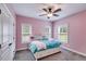 Bright bedroom featuring soft pink walls, plush carpet, and a stylish platform bed at 7269 Tyree Rd, Winston, GA 30187