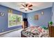 Cozy bedroom with blue walls, natural light, and comic themed decor at 7269 Tyree Rd, Winston, GA 30187