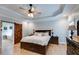 Bedroom with tray ceilings, hardwood floors, a ceiling fan, and a barn door leading to the ensuite bath at 7269 Tyree Rd, Winston, GA 30187