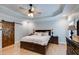 Bedroom with tray ceilings, hardwood floors, a ceiling fan, and a barn door at 7269 Tyree Rd, Winston, GA 30187