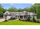 Landscaped front yard, covered porch, and two-car garage of a well-appointed home at 7269 Tyree Rd, Winston, GA 30187