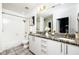 Well-lit bathroom with a double vanity, granite countertop, and shower over tub at 923 Peachtree Ne St # 1238, Atlanta, GA 30309