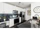 Well-lit kitchen with white cabinets, stainless steel appliances, and a black tiled backsplash at 923 Peachtree Ne St # 1238, Atlanta, GA 30309