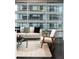 Well-lit living room featuring hardwood floors, a modern sofa, and large windows with city views at 923 Peachtree Ne St # 1238, Atlanta, GA 30309