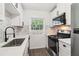 Modern kitchen featuring stainless steel appliances, white cabinets, black hardware, and marble tile backsplash at 1284 Piedmont Ne Ave # 12, Atlanta, GA 30309
