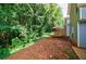 Backyard featuring a small deck, landscaping, and a wooded area at 1830 Broadway St, Decatur, GA 30035