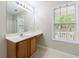 This bathroom has one sink with a mirror and a large window overlooking the backyard for natural light at 1830 Broadway St, Decatur, GA 30035