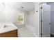 Bright bathroom featuring a single sink vanity, a bathtub with shower, and a window for natural light and ventilation at 1830 Broadway St, Decatur, GA 30035