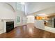 Open-concept living room featuring a fireplace, hardwood floors, and a view of the kitchen at 1830 Broadway St, Decatur, GA 30035