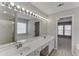 Bathroom featuring double sinks, vanity with lighting, and shower with glass door at 2421 Elkhorn Ter, Duluth, GA 30096