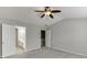 Bedroom with gray walls, carpet flooring, ceiling fan, and doorways to bathroom and closet at 2421 Elkhorn Ter, Duluth, GA 30096