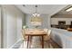 Bright dining area featuring a modern chandelier, cozy rug, neutral walls, and view to kitchen at 2421 Elkhorn Ter, Duluth, GA 30096