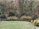 Beautiful backyard features a well-maintained lawn and lush landscaping against a backdrop of trees at 6738 Brookfield Way, Douglasville, GA 30134