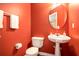 Bathroom with red walls, pedestal sink, and toilet at 6738 Brookfield Way, Douglasville, GA 30134