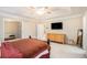 Primary bedroom with a tray ceiling, neutral walls, carpeted floor, and dark wood furniture at 6738 Brookfield Way, Douglasville, GA 30134