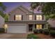 Charming two-story home with a well-manicured lawn and attached two-car garage at twilight at 6738 Brookfield Way, Douglasville, GA 30134