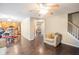 Open hallway with hardwood floors, view of kitchen, chair with pillow, and staircase at 6738 Brookfield Way, Douglasville, GA 30134