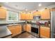 Modern kitchen with stainless steel appliances, light wood cabinets, and dark countertops at 6738 Brookfield Way, Douglasville, GA 30134