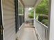 A view of the cozy front porch featuring white pillars and shaded by greenery at 6738 Brookfield Way, Douglasville, GA 30134