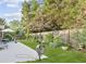 Backyard with a patio set, lush green lawn, and a wooden fence surrounded by mature trees at 117A Laguna Springs Dr, Woodstock, GA 30188