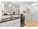The kitchen features black countertops, stainless steel appliances and is open to other rooms at 117A Laguna Springs Dr, Woodstock, GA 30188