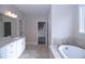 Spacious bathroom with double sink vanity, soaking tub, and stone-look tile flooring, offering a luxurious and functional design at 14 Berkten Ct, Hiram, GA 30141
