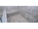 Detailed view of the shower featuring a built-in seat and gray stone-look tile creating a modern and luxurious space at 14 Berkten Ct, Hiram, GA 30141