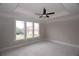 Spacious bedroom featuring a tray ceiling with a ceiling fan, large windows, and neutral walls at 14 Berkten Ct, Hiram, GA 30141