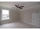 Spacious bedroom featuring a ceiling fan, a window with neighborhood views, and an access door at 14 Berkten Ct, Hiram, GA 30141