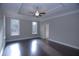Main bedroom boasts hardwood floors, a ceiling fan, and tray ceiling, creating a luxurious retreat at 14 Berkten Ct, Hiram, GA 30141