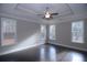 Main bedroom with hardwood floors, tray ceiling, and ample natural light from large windows at 14 Berkten Ct, Hiram, GA 30141